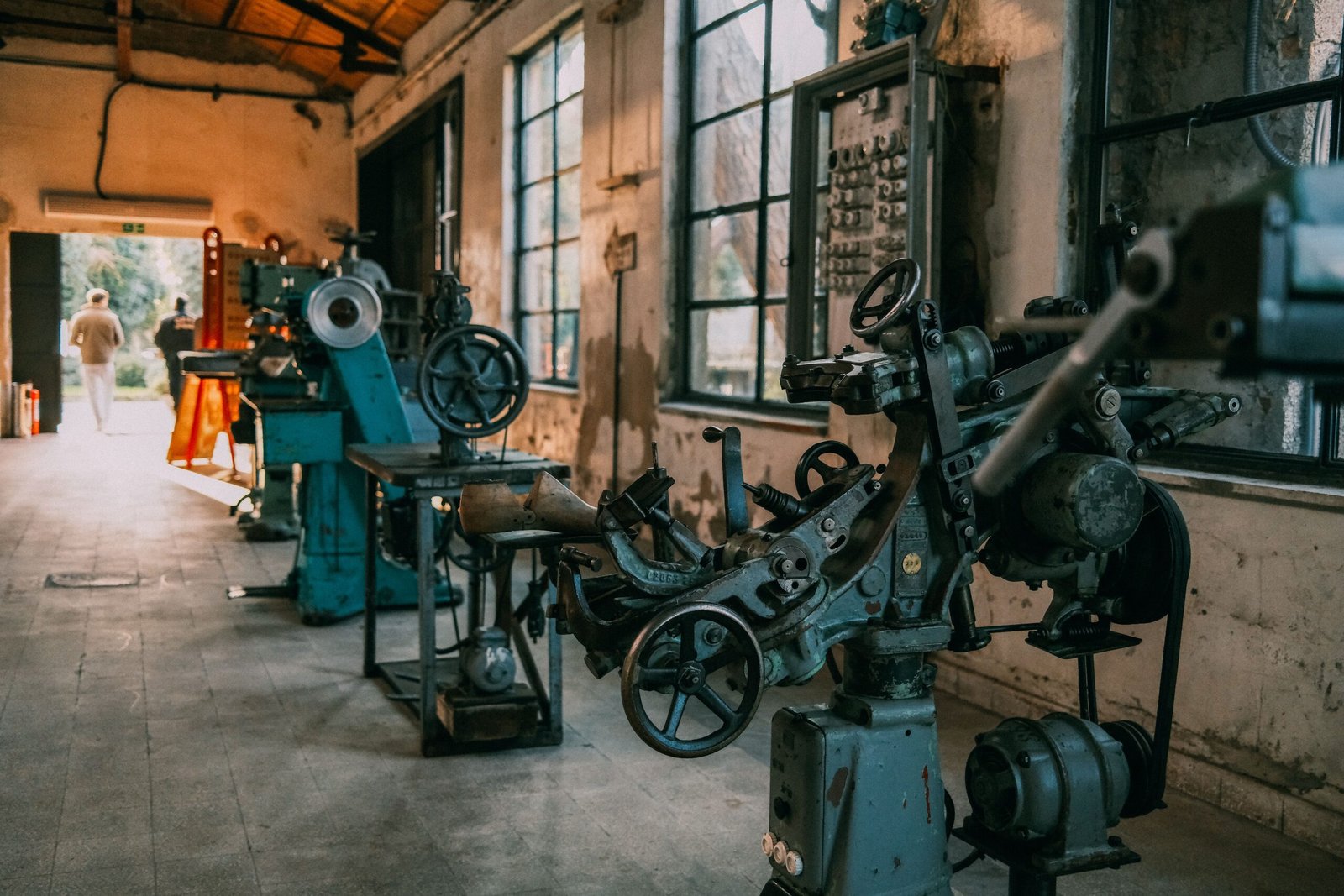 Home Explore a vintage workshop filled with historic machinery in a rustic setting.